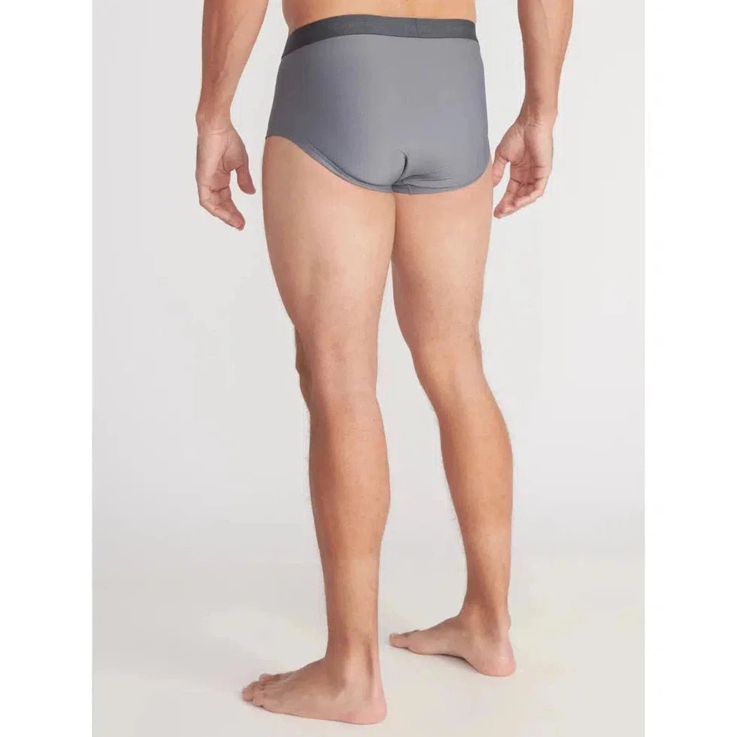 Back view of the Exofficio Men's Give-N-Go 2.0 Brief in Black on a barefoot model against a plain white background.