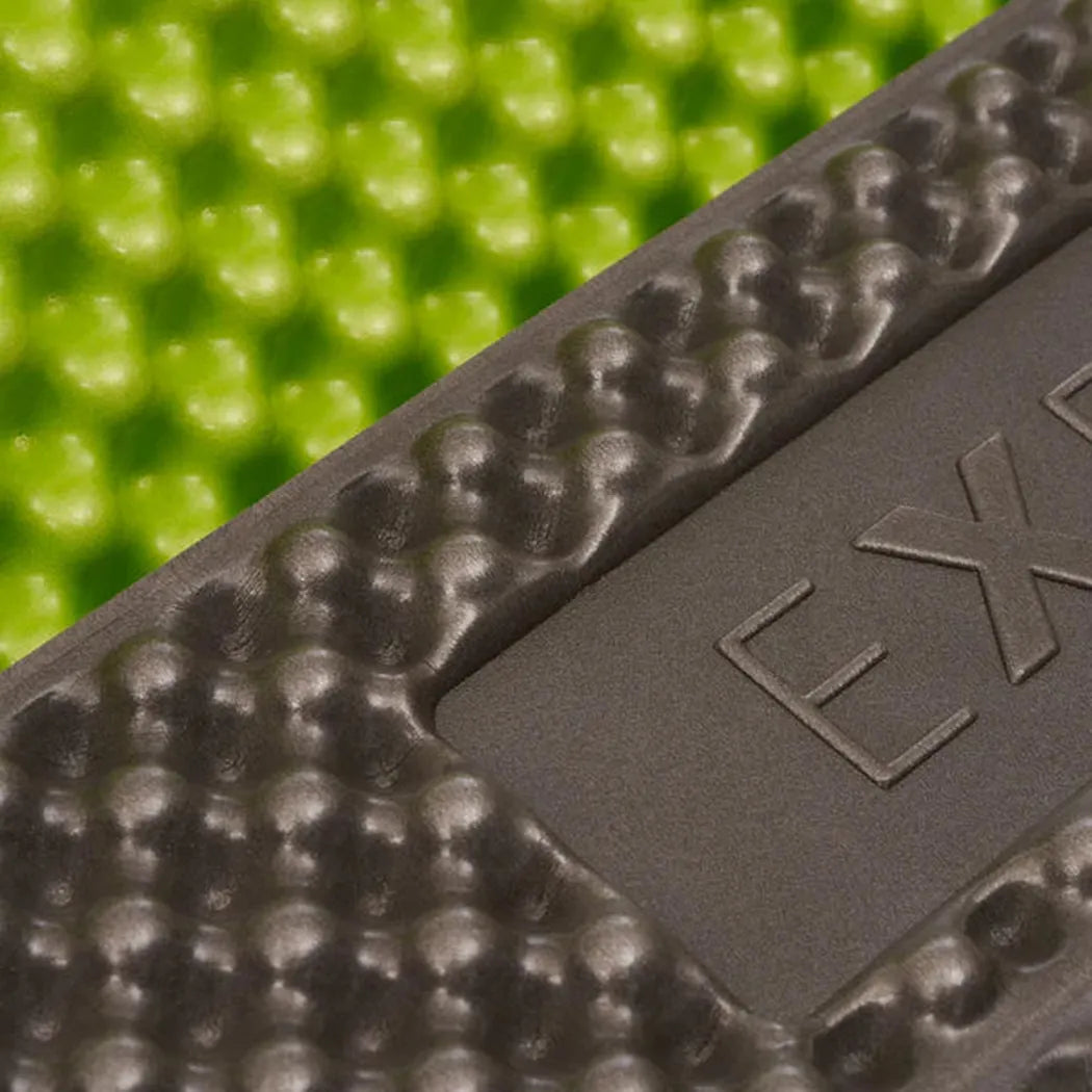A close-up of the Exped Flex 1.5R sleeping pad in Lichen M color, showing the textured surface and embossed logo against a green background.