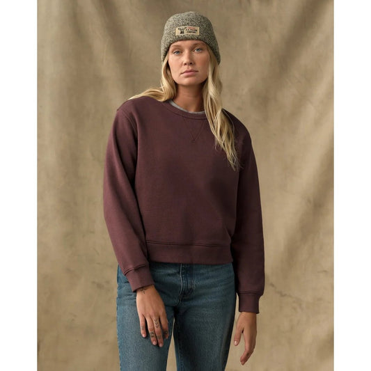 A woman wearing the Filson Womens French Terry Crewneck in Eagle Brown stands against a neutral background.