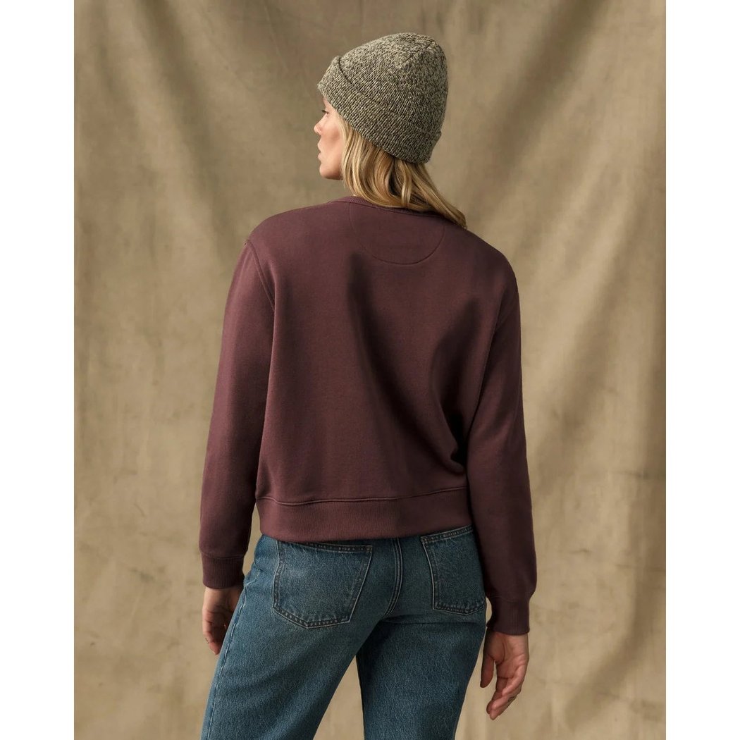 Back view of the Filson Womens French Terry Crewneck in Eagle Brown on a model wearing blue jeans against a neutral background.