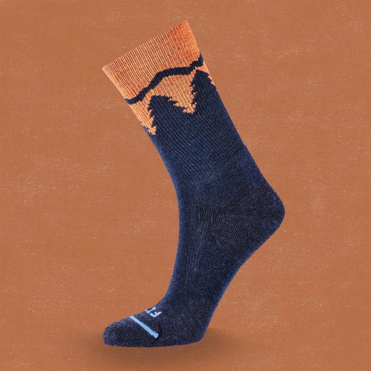 Side view of the FITS Light Hiker Crew in Coal showing the mountain graphic on the cuff against a brown background.