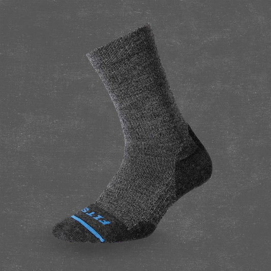Side view of the FITS Light Hiker Crew sock in Coal color showing the toe and heel reinforcement against a dark gray background.
