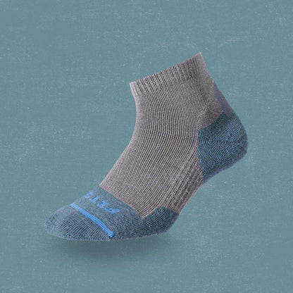 Side view of the FITS Light Hiker Quarter in Coal showing the quarter length and reinforced heel and toe against a solid teal background.