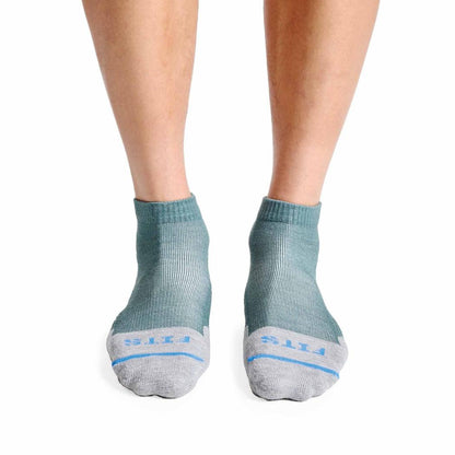 A front view of the FITS Light Hiker Quarter socks in Coal color on a person's feet against a white background.