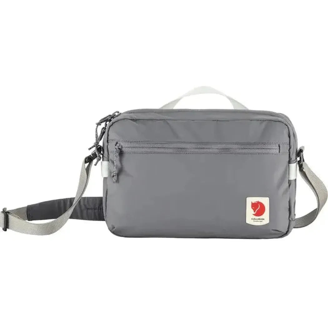 A front view of the Fjallraven High Coast Crossbody in Black with a zippered front pocket and adjustable strap against a white background.