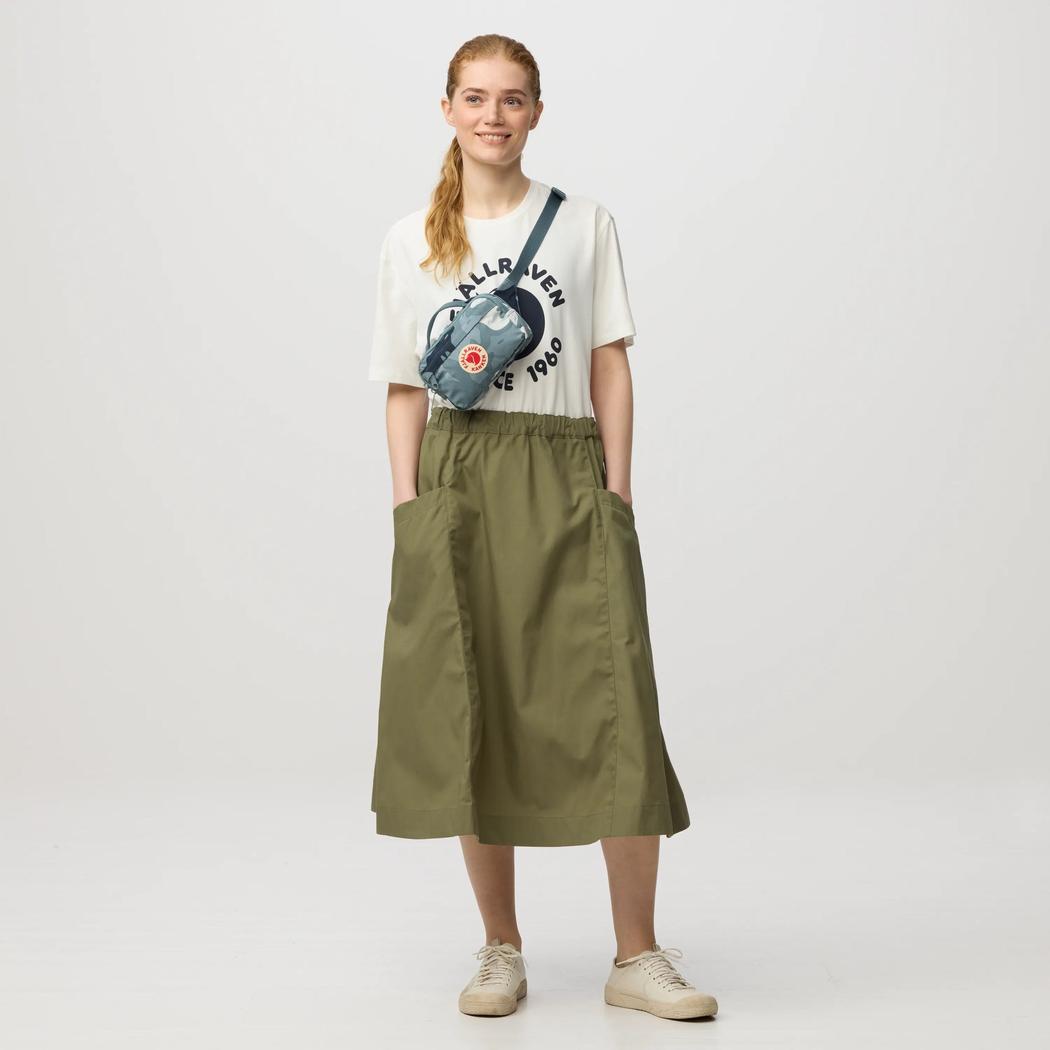 A model wearing the Fjallraven Kanken Graphics Hip Pack in Chalk Rose-Hidden Animals stands against a plain white background.