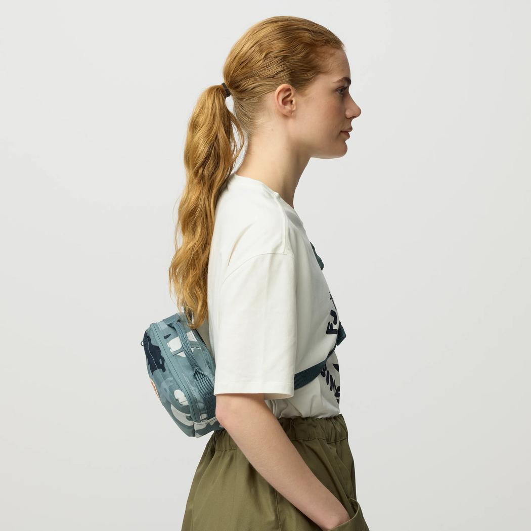 Side view of the Fjallraven Kanken Graphics Hip Pack in Chalk Rose-Hidden Animals on a model against a white background.