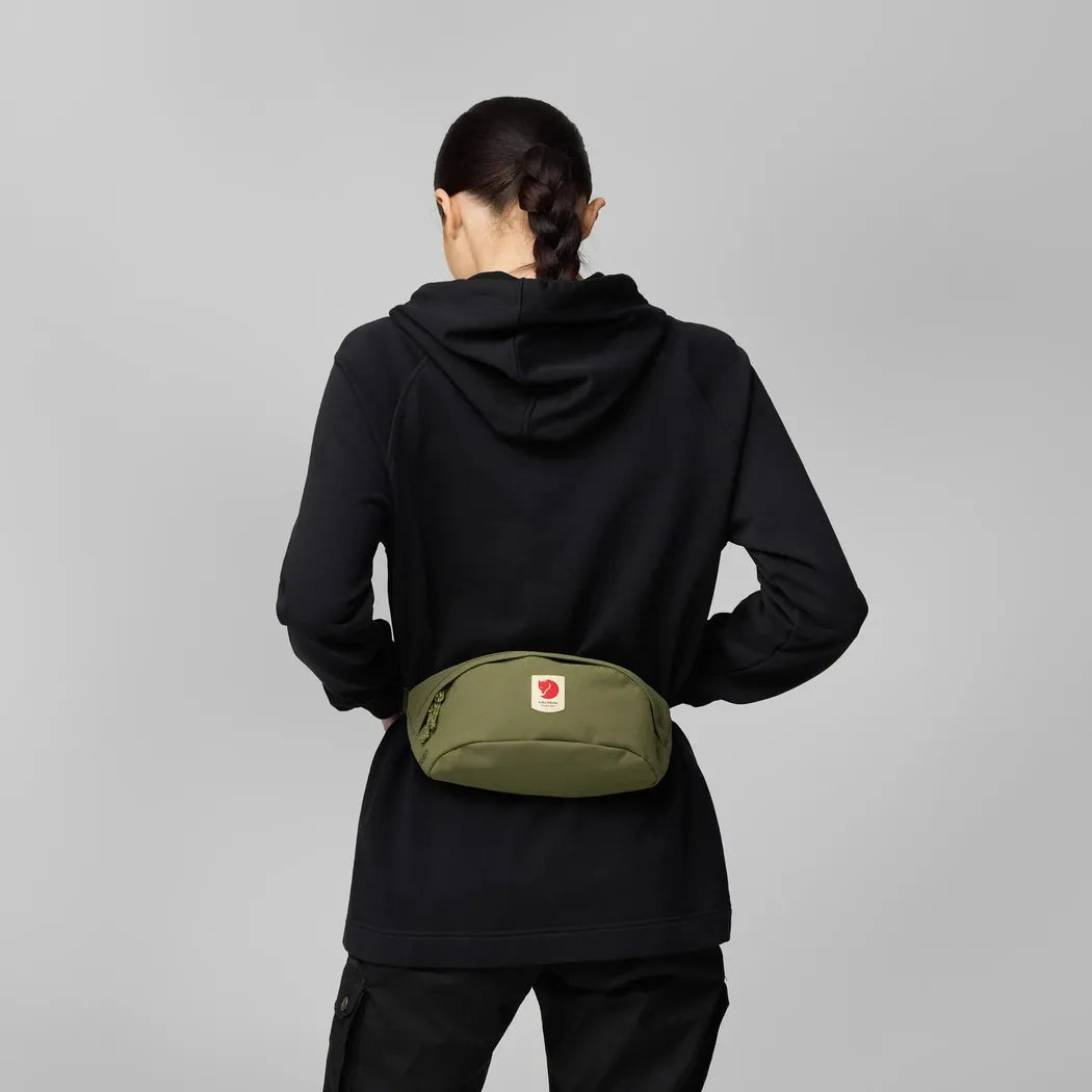 Back view of the Fjallraven Ulvo Hip Pack Medium in Black on a model against a gray background.