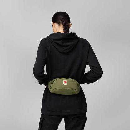 Back view of the Fjallraven Ulvo Hip Pack Medium in Black on a model against a gray background.