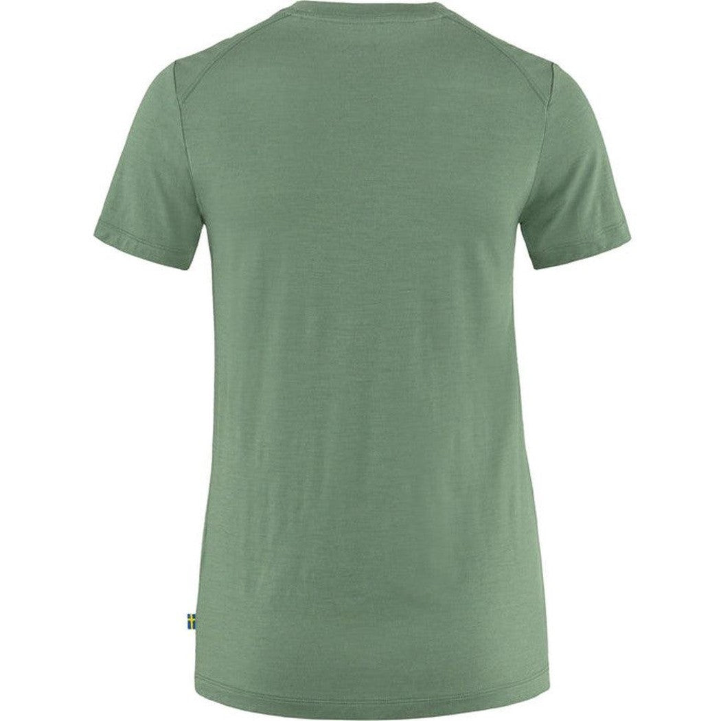 Back view of the Fjallraven Women's Abisko Wool Short Sleeve in Patina Green with a small tag on the lower left hem against a white background.