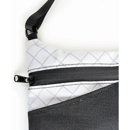 The Flowfold Eclipse Crossbody bag in Jet Black shows the zipper and shoulder strap against a white background.