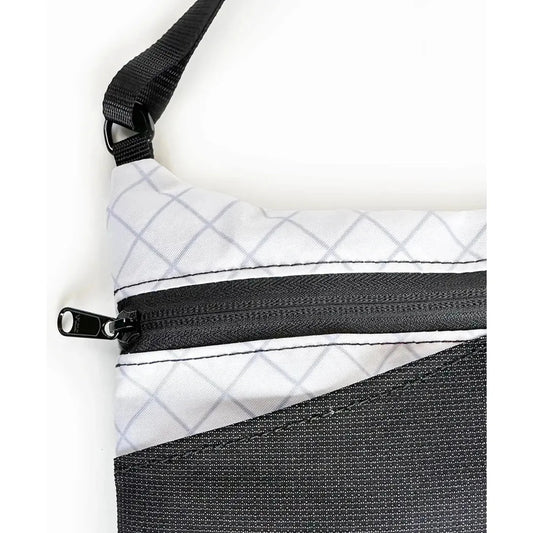 The Flowfold Eclipse Crossbody bag in Jet Black shows the zipper and shoulder strap against a white background.