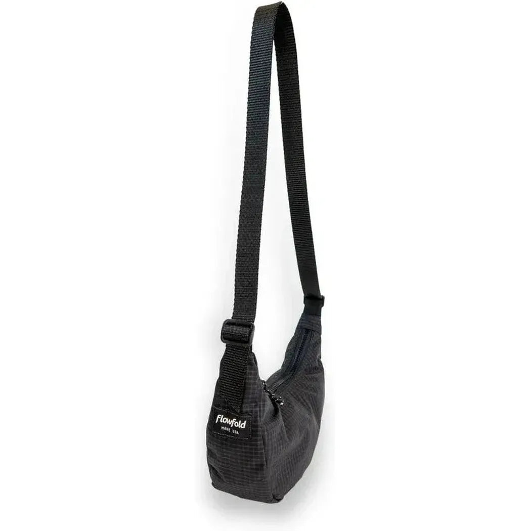 A side view of the Flowfold Mini Culter Crossbody in Coal EcoGrid with a black strap and adjustable buckle against a white background.