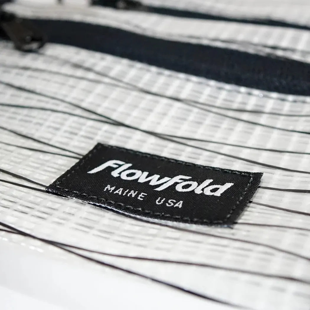 A close-up of the Flowfold Recycled Sailcloth Voyager Zipper Pouches - Set of 3, showing the black sailcloth label and zipper against a white background.