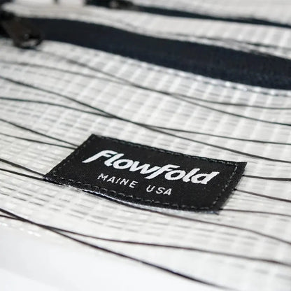 A close-up of the Flowfold Recycled Sailcloth Voyager Zipper Pouches - Set of 3, showing the black sailcloth label and zipper against a white background.