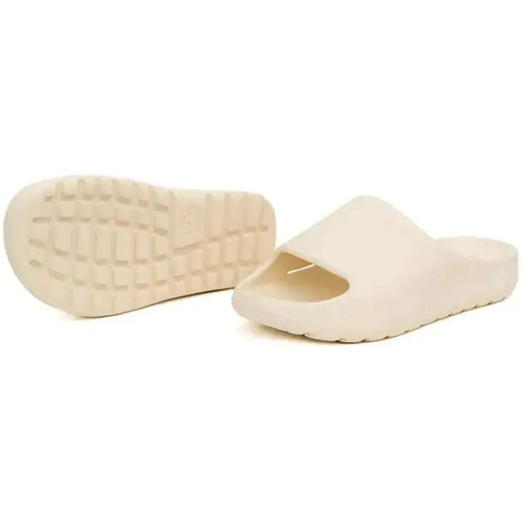 Side view of the Freewaters Women's Cloud9 Slide in Bone showing the textured outsole and open toe design against a white background.
