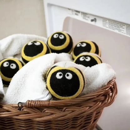 A basket of Charcoal/Graphite Friendsheep Bee Trio Eco Wool Dryer Balls sits on a white surface near a white appliance.