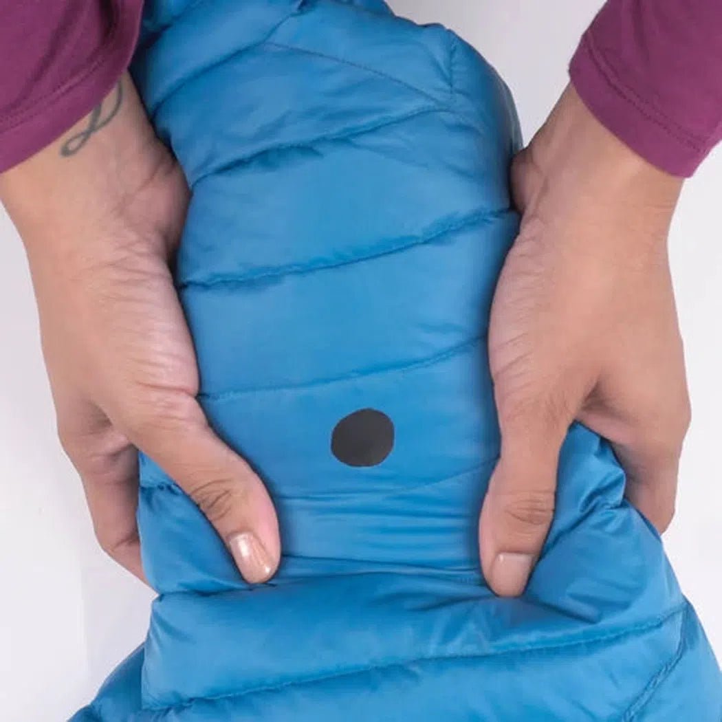 A person holds the Gear Aid Aquaseal FD Repair Kit in a blue jacket with a black dot, showing the product against a white background.