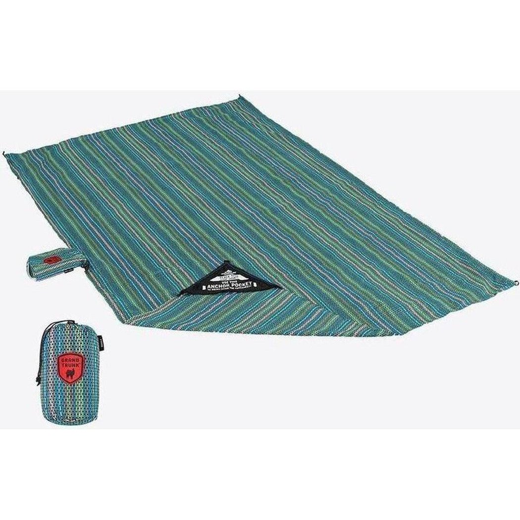 A flat lay photo of the Grand Trunk Adventure Sheet in Cabo color, showing the folded blanket and its compact storage bag.
