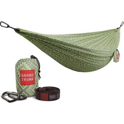 A green Grand Trunk Double Deluxe Hammock with suspension straps and a matching bag displayed on a white background.