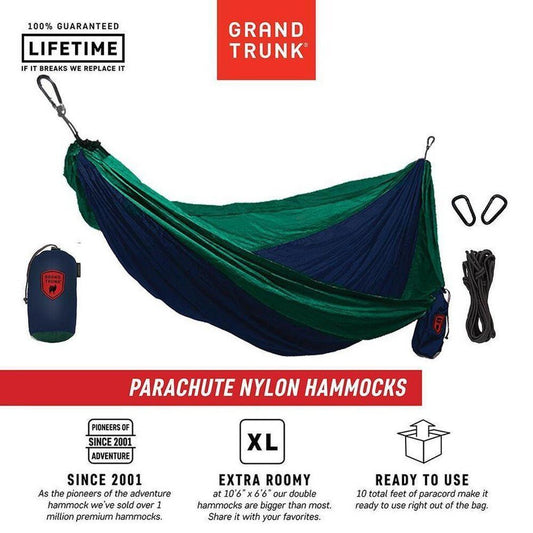 A Grand Trunk Double Parachute Nylon Hammock in Green/Blue is shown from a front angle with its straps and storage bag visible.