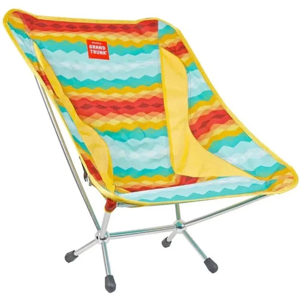 A side view of the Grand Trunk Mantis camping chair in Black with a metal frame and black feet against a white background.