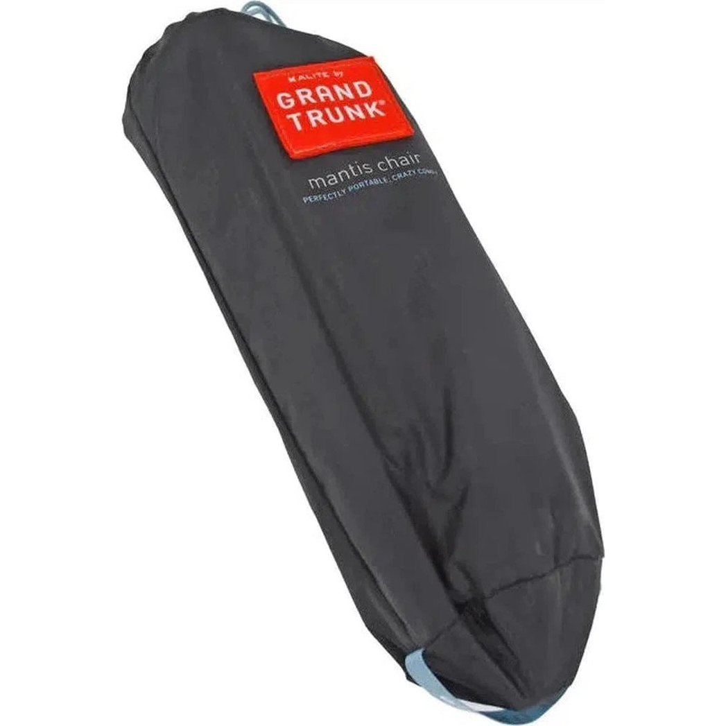 A black Grand Trunk Mantis chair in its carry bag, showing the red brand label and a light blue strap at the bottom.