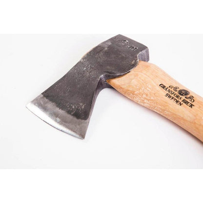 A close-up of the Gransfors Bruk Hand Hatchet with a light wooden handle and a dark metal head, photographed against a plain white background.