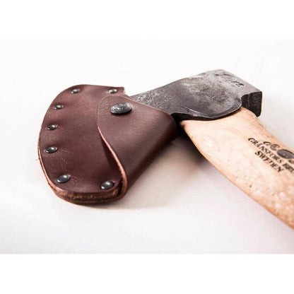 A left bevel Gransfors Bruk Swedish Carving Axe with a brown leather sheath rests on a white background.