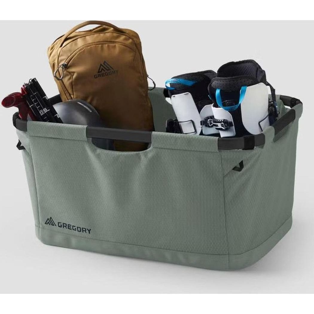 A front view of the Nomad Green Gregory Alpaca Gear Basket 70 filled with gear against a white background.