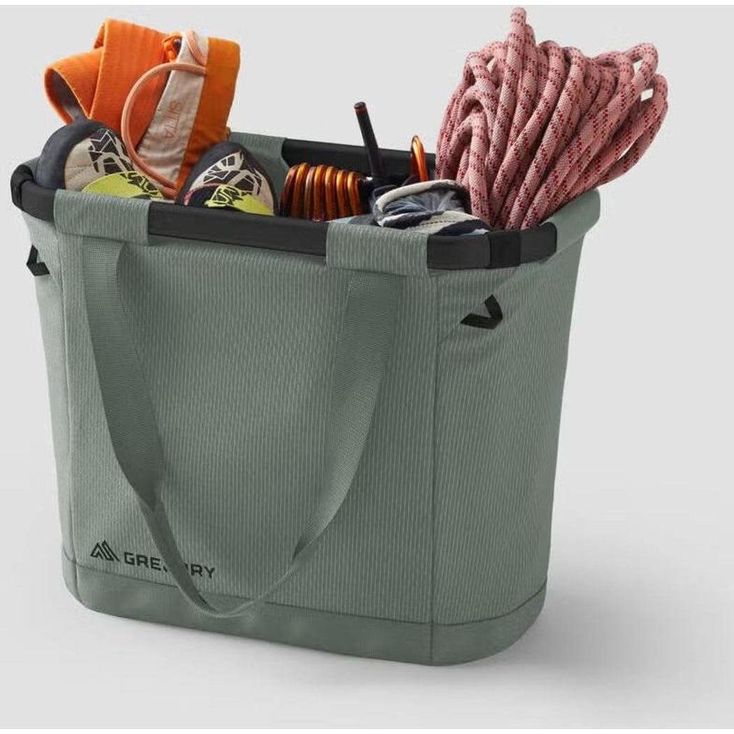 A top-down view of the Nomad Green Gregory Alpaca Gear Tote 30 filled with camping gear like a rope and coiled cord against a plain background.