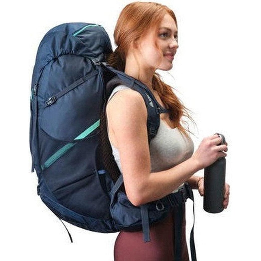 Side view of the Gregory Amber 68 in Coral Blue showing the large main compartment and a model wearing it against a white background.