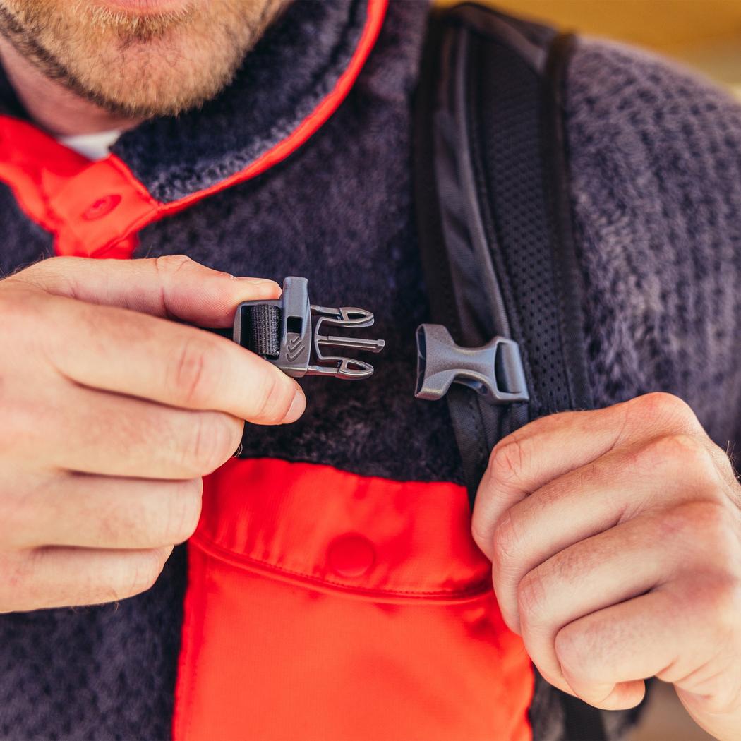 A close-up of a man wearing the Gregory Nano 16 daypack in Moab Tan, showing the buckle and strap detail.