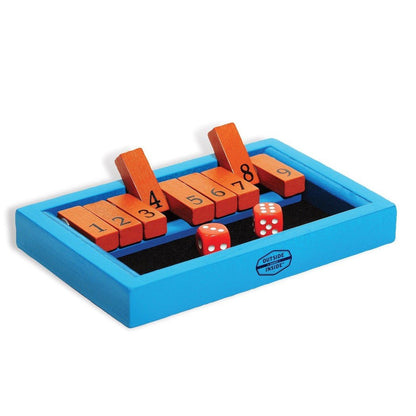 A blue GSI Outdoors Backpack Shut the Box game with orange numbered blocks and red dice on a black surface.