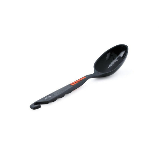 A side view of the GSI Outdoors Pack Spoon with a charcoal handle and orange accents against a white background.