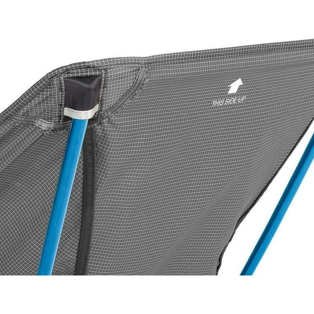 A close-up of the Helinox Chair Zero L in Black showing the "This Side Up" label and blue frame against a white background.