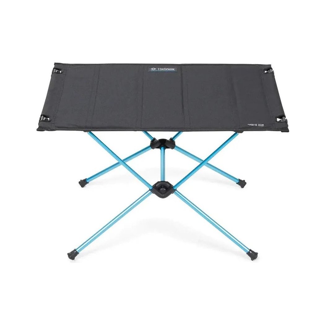 A top-down view of the Helinox Table One Hard Top in Black R1 with a blue metal frame and black rubber feet, set against a white background.