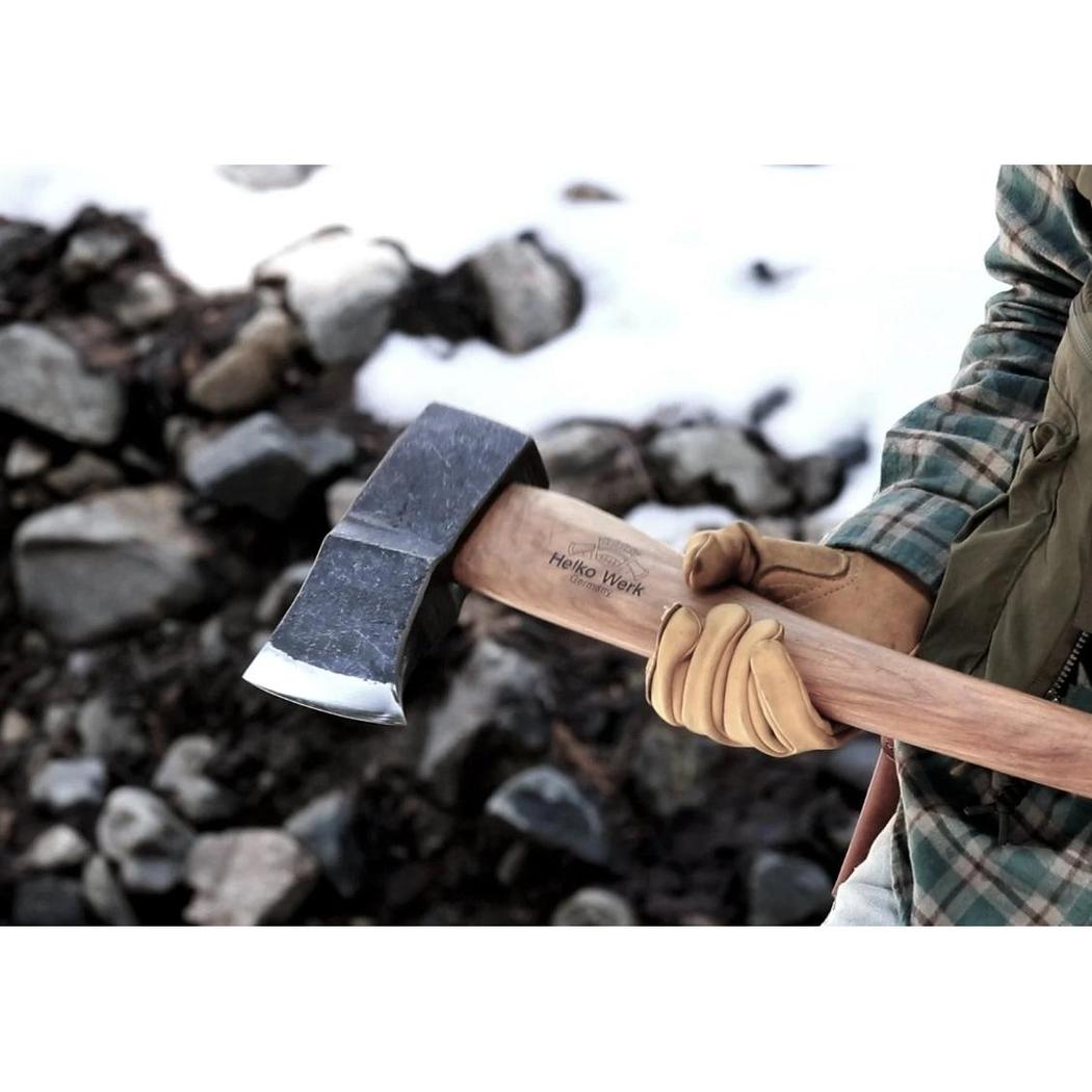 A person wearing tan gloves holds the Helko Werk Saxon Splitter axe with a snowy, rocky background.