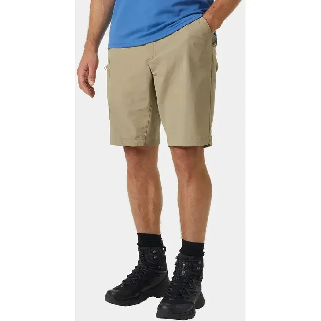 Side view of the Helly Hansen Men's Brono Softshell Shorts in Pebble on a model wearing black hiking boots against a white background.