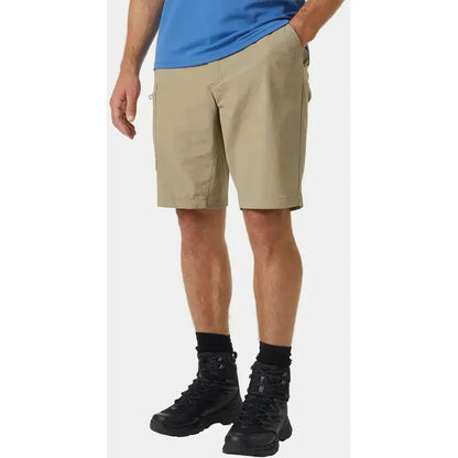 Side view of the Helly Hansen Men's Brono Softshell Shorts in Pebble on a model wearing black hiking boots against a white background.