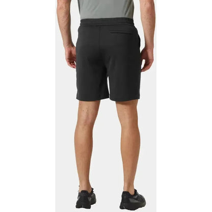 Back view of the Helly Hansen Men's LIFA Tech Lite Shorts in Black on a model wearing black shoes against a white background.