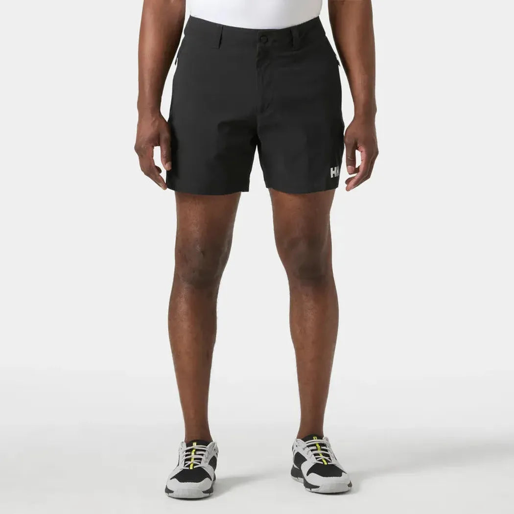 A front view of the Helly Hansen Men's Move Quick Dry 6” Shorts in Black on a model wearing white sneakers against a plain white background.