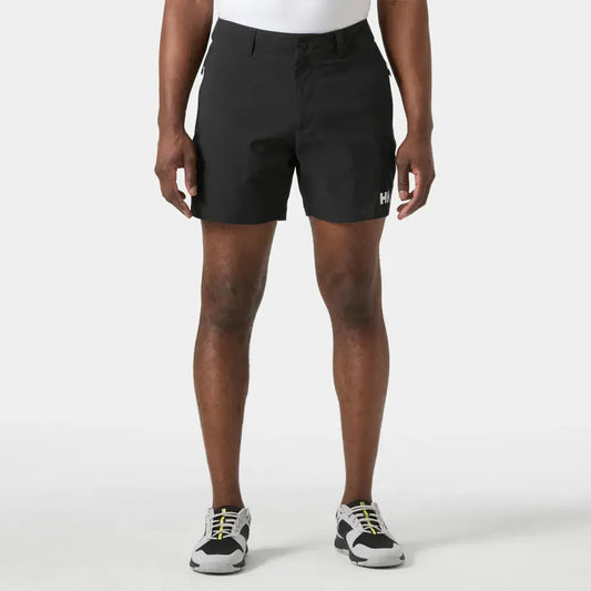 A front view of the Helly Hansen Men's Move Quick Dry 6” Shorts in Black on a model wearing white sneakers against a plain white background.