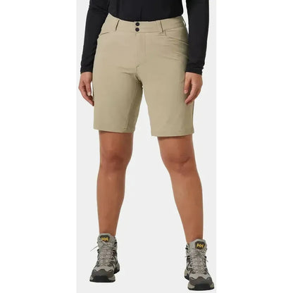 A front view of the Helly Hansen Women's Brona Softshell Shorts in Pebble, showing the model wearing them with hiking boots against a plain background.