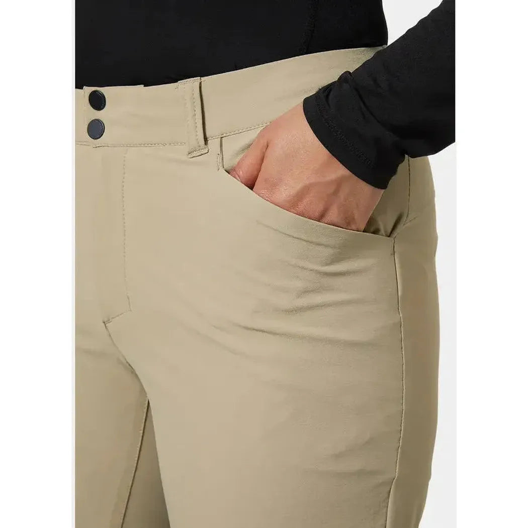 Side view of the Helly Hansen Women's Brona Softshell Shorts in Pebble showing the front pocket and model's hand in it.