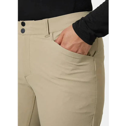 Side view of the Helly Hansen Women's Brona Softshell Shorts in Pebble showing the front pocket and model's hand in it.