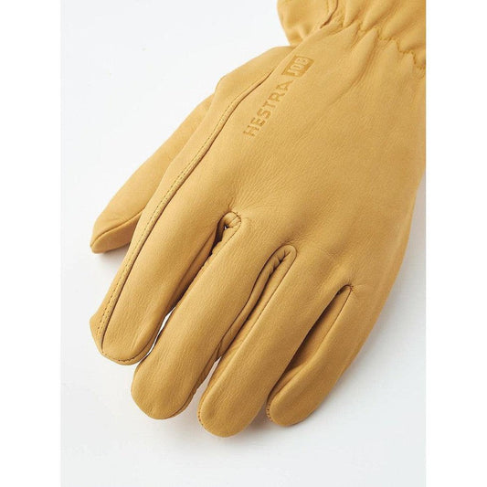 A close-up of the Hestra Job Cow Driver Uninsulated glove in yellow, showing the stitching and logo on a white background.
