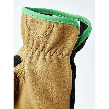 A close-up of the Hestra Job Golden Kobolt glove showing its tan leather and green trim against a white background.