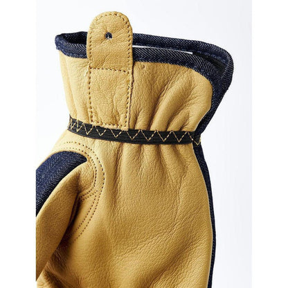 Side view of the Hestra Job Kobolt Denim work glove showing the indigo denim cuff and stitching against a white background.