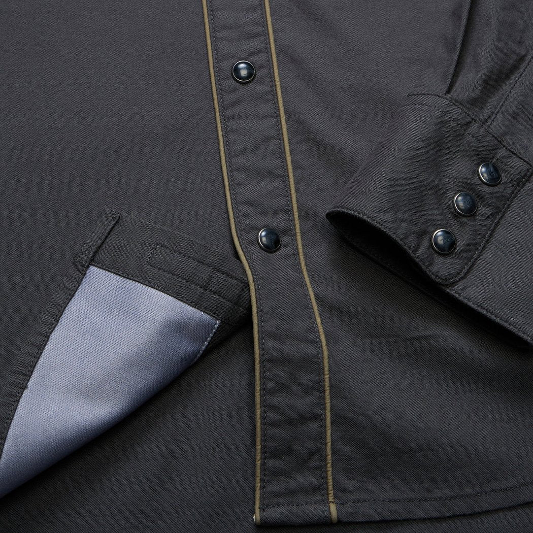 A close-up of the Howler Brothers Broncbuster Longsleeve Snapshirt in MoonlessNight showing the snap buttons and pocket lining.